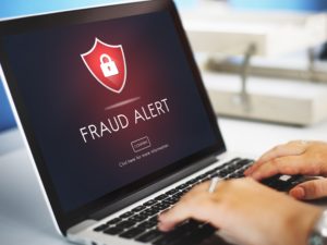 A laptop that says "Fraud Alert"