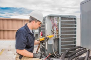 HVAC specialist works on air conditioning unit as a part of preventative maintenance.